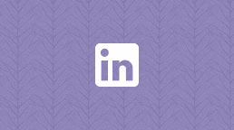 A white LinkedIn logo displayed on a purple patterned background. The logo features the letters 'in' in a bold font, enclosed within a square.